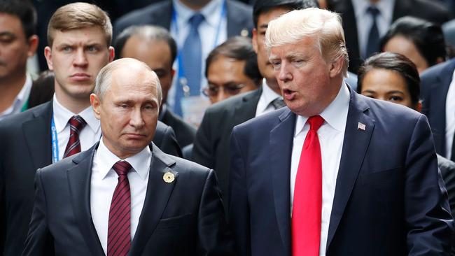 (FILES) In this file photo taken on November 11, 2017 US President Donald Trump (R) and Russia's President Vladimir Putin talk as they make their way to take the "family photo" during the Asia-Pacific Economic Cooperation (APEC) leaders' summit in the central Vietnamese city of Danang. With the surprise indictment on February 16, 2018 of 13 Russians for meddling in the US election, Special Counsel Robert Mueller's investigation of possible collusion between Donald Trump's 2016 campaign and Moscow has entered new territory.In the first charges directly related to the election, the indicted Russians were accused of running a secret campaign to tilt the vote, including by churning out online posts that were damaging to Trump's political rivals.  / AFP PHOTO / POOL / JORGE SILVA