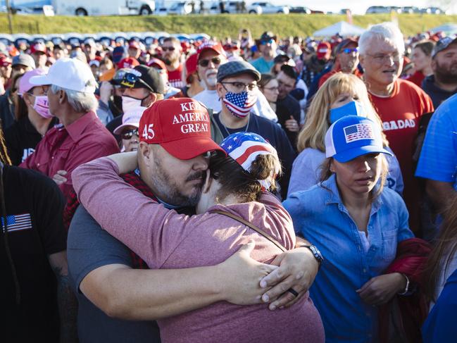 A couple hugs in the crowd while waiting for Donald Trump to arrive at the North Carolina rally. Picture: Angus Mordant