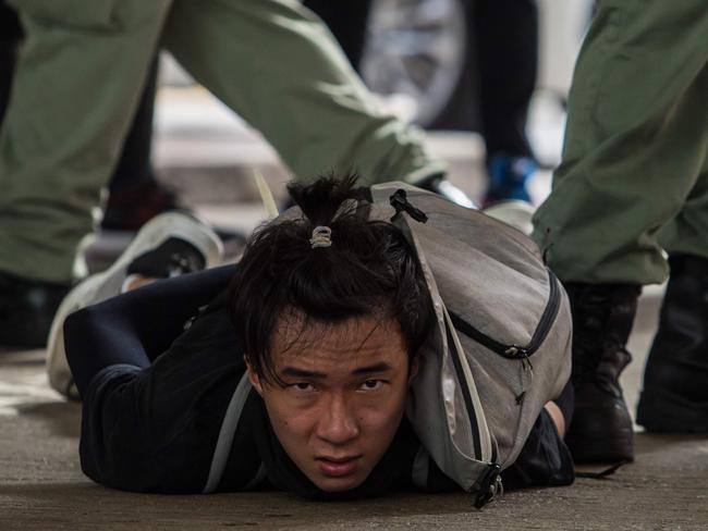 TOPSHOT - Riot police detain a man as they clear protesters taking part in a rally against a new national security law in Hong Kong on July 1, 2020, on the 23rd anniversary of the city's handover from Britain to China. - Hong Kong police made the first arrests under Beijing's new national security law on July 1 as the city greeted the anniversary of its handover to China with protesters fleeing water cannon. (Photo by DALE DE LA REY / AFP)