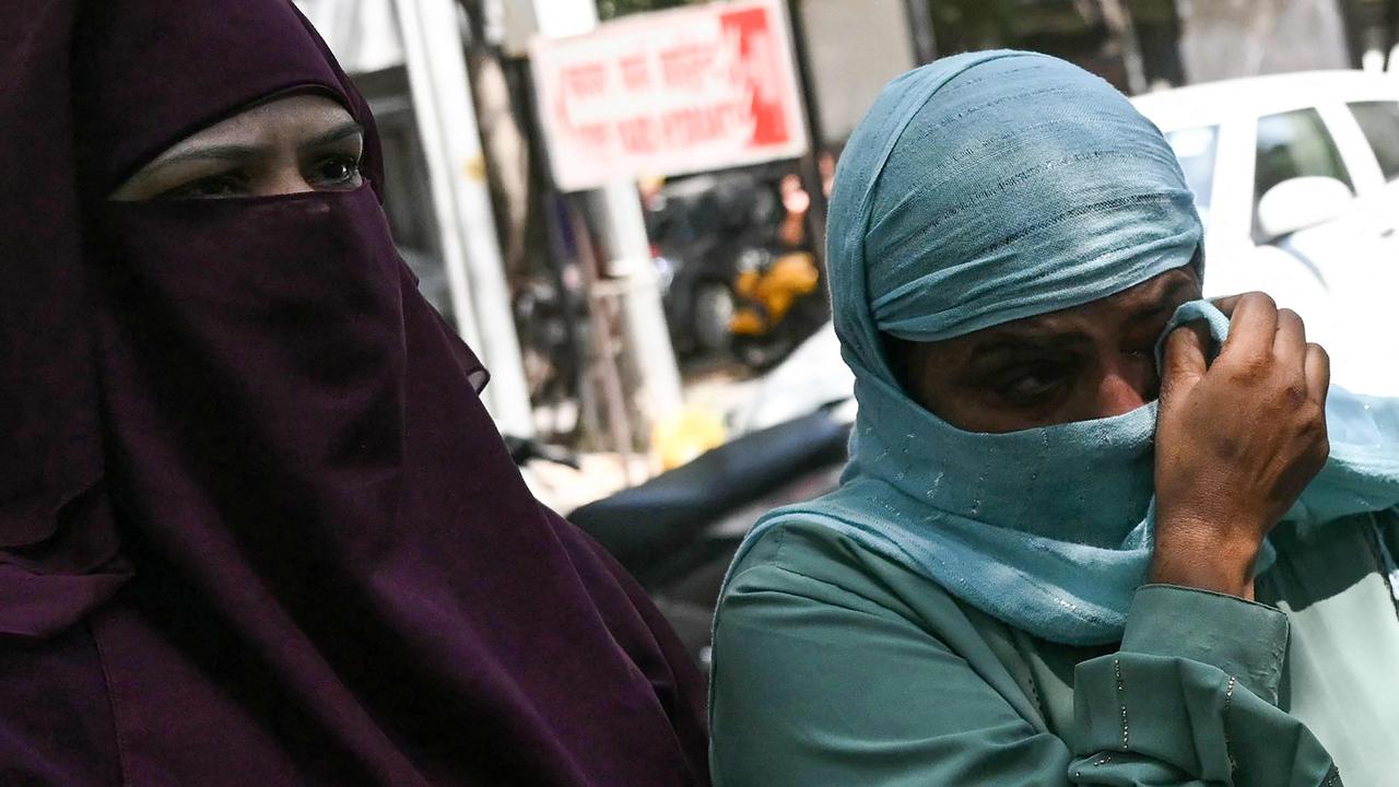 A relative (right) of an infant victim cries as she waits to identify them outside a mortuary a day after a fire blazed through a children's hospital in New Delhi on May 26, 2024. Picture: AFP.