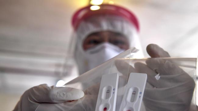 A health worker handles a new rapid testing kit to combat the spread of the COVID-19 novel coronavirus at Chulalongkorn University in Bangkok. Dodgy DIY testing kits have been intercepted in Australia.