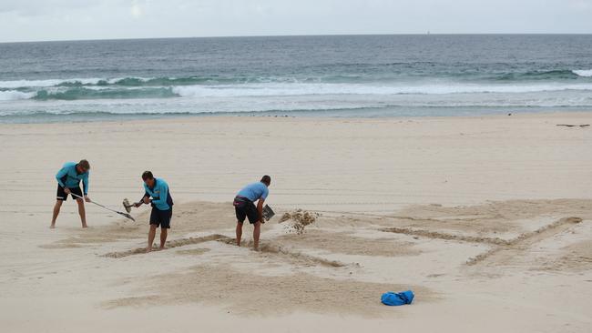 Bondi Rescue Lifeguards on Bondi Beach writing #stayhome in the sand, on the first morning of new restrictions to help limit the spread of COVID-19. Picture Rohan Kelly