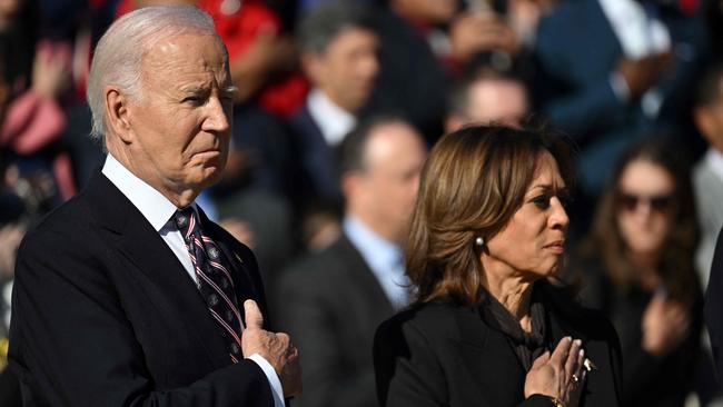 Joe Biden and Kamala Harris stand at attention during a wreath-laying ceremony at The Tomb of the Unknown Soldier at Arlington National Cemetery.