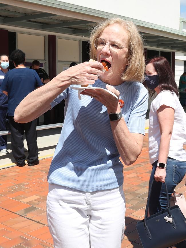 Chief Health Officer Jeannette Young samples the sausage sizzle at Deception Bay State High School’s vaccination clinic. Picture: Annette Dew