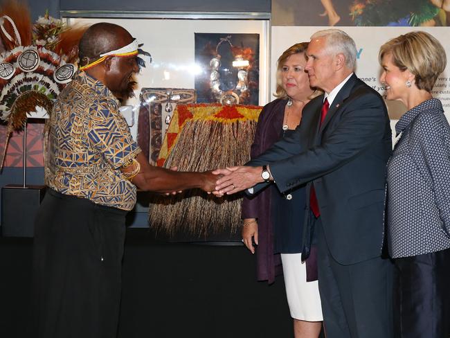 Vice President Mike Pence, with Foreign Minister Julie Bishop (right), shakes hands with Dr Michael Mel, wearing a traditional Papa New Guinea outfit, during a visit to the Australian Museum. Picture: AAP Image/David Moir