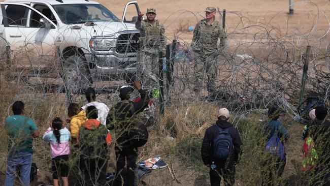 Texas National Guard agents prevent migrants from Venezuela from crossing a barbed wire fence at the El Paso Sector Border. Picture: AFP