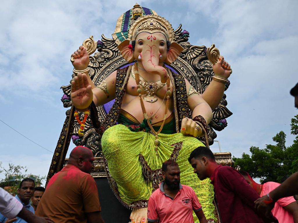 TOPSHOT - Devotees carry an idol of elephant-headed Hindu deity Ganesha during a procession ahead of the Ganesh Chaturthi festival in Mumbai on August 30, 2022. (Photo by Punit PARANJPE / AFP)