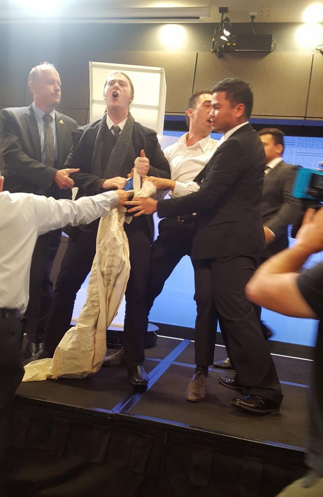 A protester has rushed the stage during Simon Birmingham's address to the Press Club in Canberra. Picture: Peter Jean