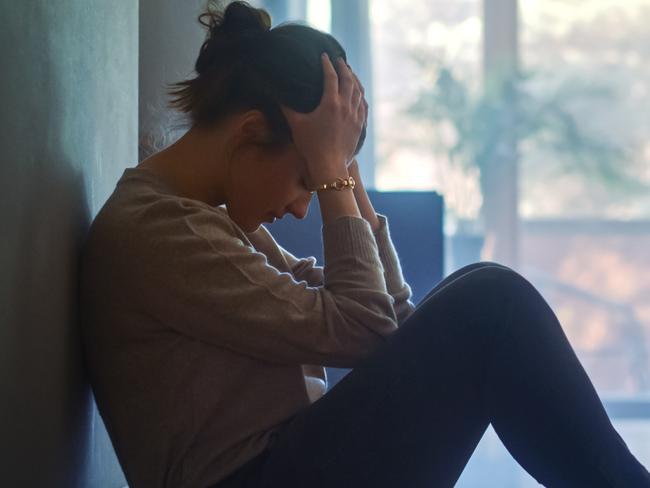 istock generic:  woman, abuse, DV, domestic violence, harassment, sexual harassment.   Sad Young Woman Sitting on the Floor In the Hallway of Her Appartment, Covering Face with Hands. Atmosphere of Depression, Trouble in Relationship, Death in the Family. Dramatic Bad News Moment . Picture: istock