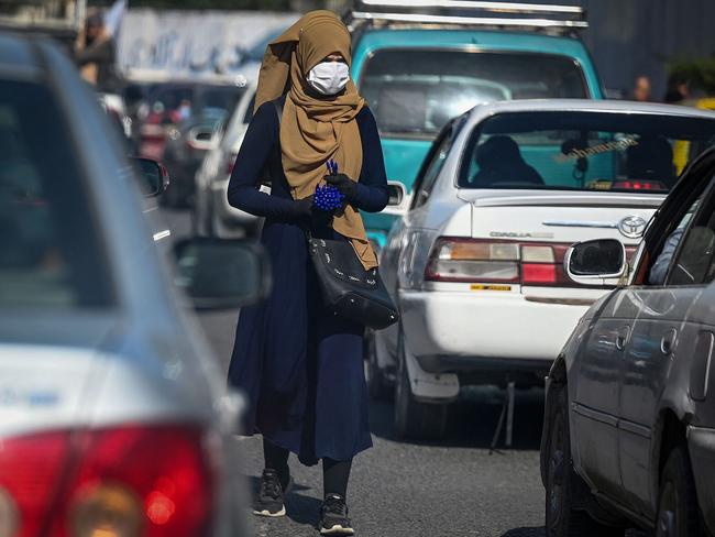 An Afghan woman hawker attempts to sell pens to commuter traffic in Kabul. Picture: AFP