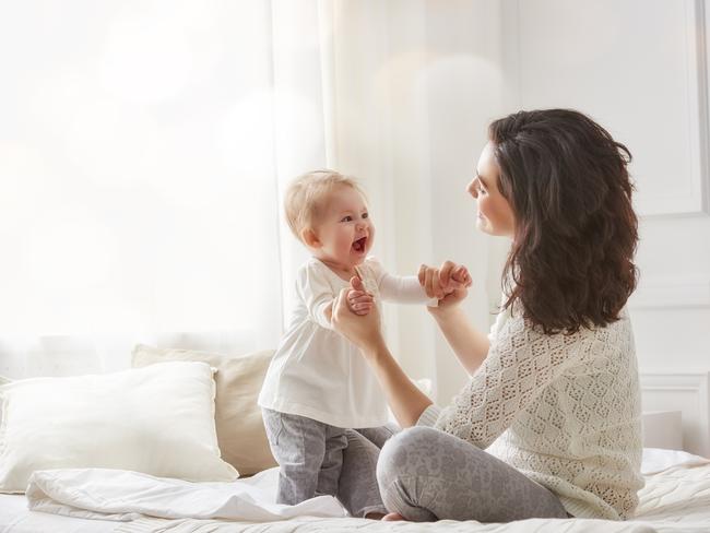 happy loving family. mother playing with her baby in the bedroom.