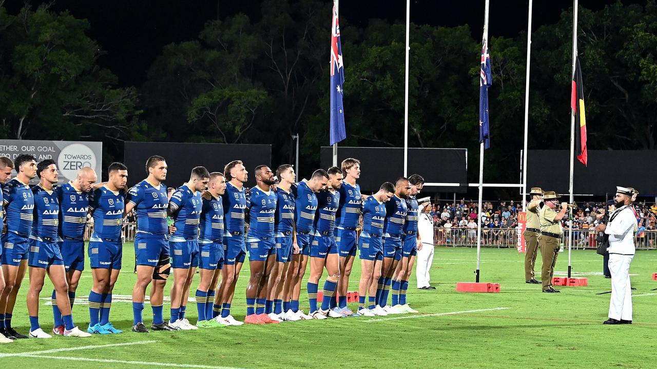 Players embrace for the last post played in remembrance of ANZAC Day before the round eight NRL match between Parramatta Eels and Brisbane Broncos at TIO Stadium on April 21, 2023 in Darwin, Australia. (Photo by Bradley Kanaris/Getty Images)