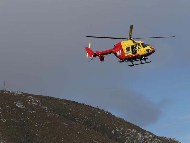 Tasmania Police helicopter coming in to refuel at a helipad outside Pedder Wilderness Lodge yesterday. Picture: LUKE BOWDEN