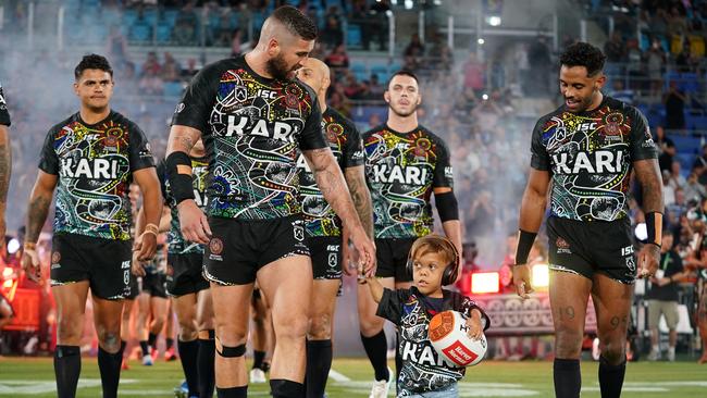 Quaden Bayles, (9), leads the Indigenous All Stars on to the field with captain Joel Thompson. Picture: AAP