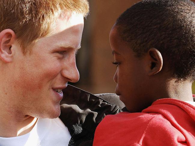 LESOTHO - APRIL 24: (EMBARGOED: NOT FOR PUBLICATION BEFORE 0001 FRIDAY APRIL 28, 2006.) Prince Harry holds his old friend, Mutsu Potsane, in the grounds of the Mants'ase children's home, while on a return visit to Lesotho on April 24, 2006 in southern Africa. The Prince was in the country to launch his new charity called 'Sentebale', which means 'Forget me not' in memory of his mother Princess Diana. (Photo by Pool/Anwar Hussein Collection/Getty Images)