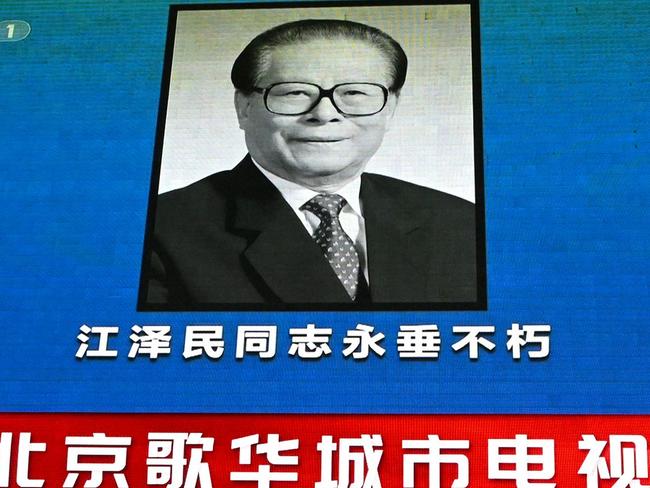 A large video screen shows news broadcast featuring an image of former Chinese leader Jiang Zemin in Beijing. Picture: AFP