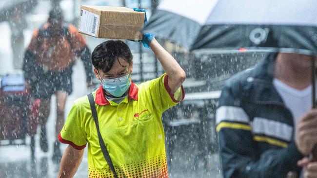 Workers in Melbourne’s CBD seek cover on Friday. Picture: Jason Edwards