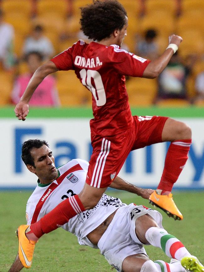 Mehrdad Pooladi of Iran tackles Omar Abdulrahman of the United Arab Emirates at Suncorp Stadium. Picture: Bradley Kanaris/Getty Images