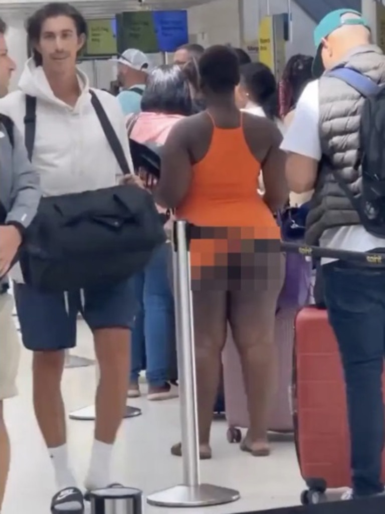 She waited in line at the Fort Lauderdale-Hollywood International Airport with her orange halter top dress hiked up. Picture: Reddit