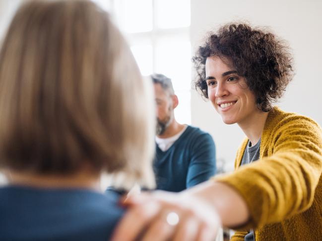 Serious men and women sitting in a circle during group therapy, supporting each other.  - picture istock