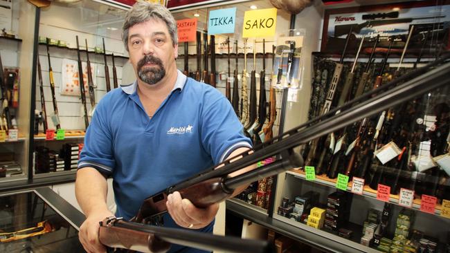 Firearms Act, State Government prepares to consider a review, gun seller Larry Collinson, of South East Firearms, Sorell, with a category A firearm, a .22 rifle (left) and a category C firearm, a 12 gauge pump-action shotgun (right)