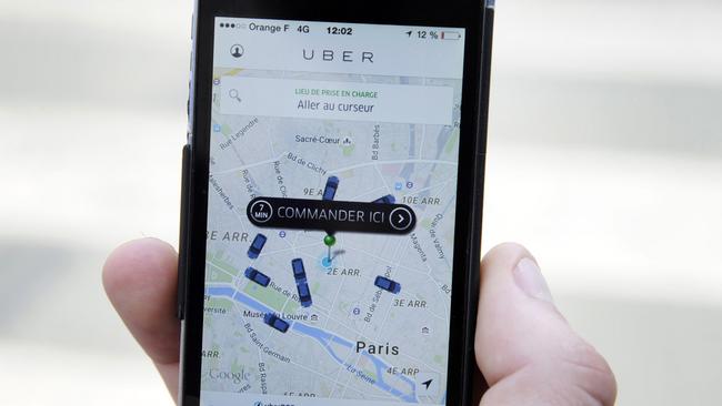 (FILES) -- A file photo taken on June 17, 2015 shows a person using the French version of the Uber app to order a UberPop cab in Paris. The two leaders of Uber in France were taken into custody on June 29, 2015 as part of a probe into their ride-booking app which has sparked violent protests from regular taxi drivers, legal sources said. The investigation was opened in 2014 into the application which is used to put paying clients in contact with cheaper, private drivers who do not face the same regulations as cabbies. Uber has faced rising anger in several countries, particularly in France where a taxi strike last week turned violent as drivers set fire to vehicles and blocked highways, creating a headache for thousands of tourists. AFP PHOTO / THOMAS OLIVA