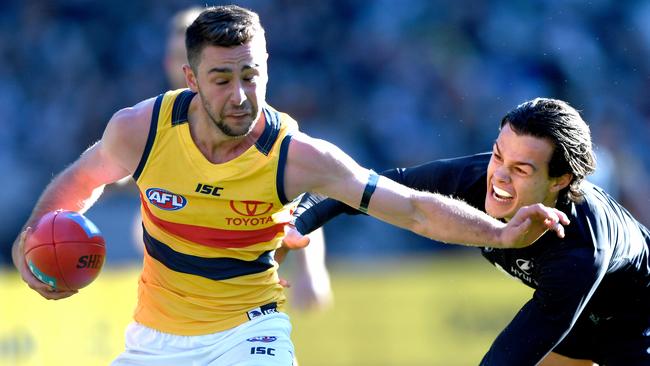 Rory Atkins beats a tackle by Carlton’s Jack Silvagni. Picture: Joe Castro (AAP)