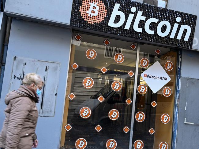 A woman walks past Bitcoin digital currency ATM shop in Marseille, southern France, on January 8, 2021. (Photo by NICOLAS TUCAT / AFP)