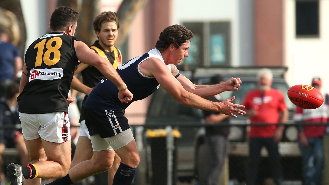 Ballarat: Marc Dransman of Melton South handpasses clear of danger. Picture: Hamish Blair