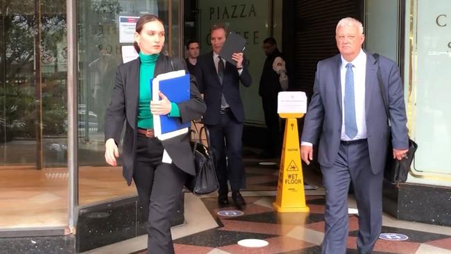 Tom Cribb (holding black folder near face) leaves court on Tuesday.