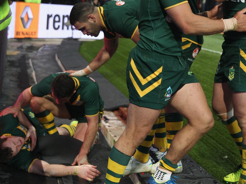 Brett Morris (L) of Australia lies injured after crashing into the advertising hordings at Old Trafford on November 30, 2013 in Manchester, England. (Photo by Michael Steele/Getty Images)