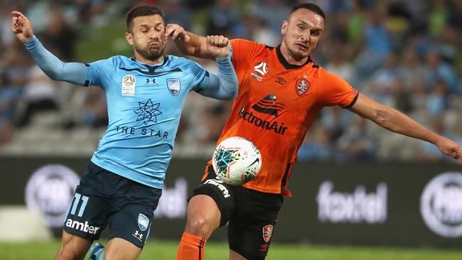 Brisbane Roar captain Tom Aldred (right) competes for the ball with Sydney FC striker Kosta Barbarouses. Picture: AAP