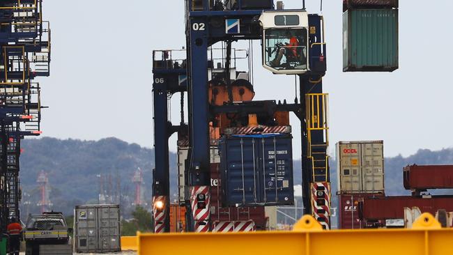 A tanker leaves as cargo ships are loaded at Port Botany. Picture: John Grainger