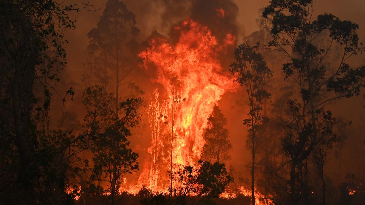 A man who travelled 200km to save his parents’ bushfire-threatened home in Bobin on New South Wales’ mid-north coast (fire pictured in the town earlier this month) has claimed he was fired from his job for taking time off work. Picture: Peter Parks/AFP.