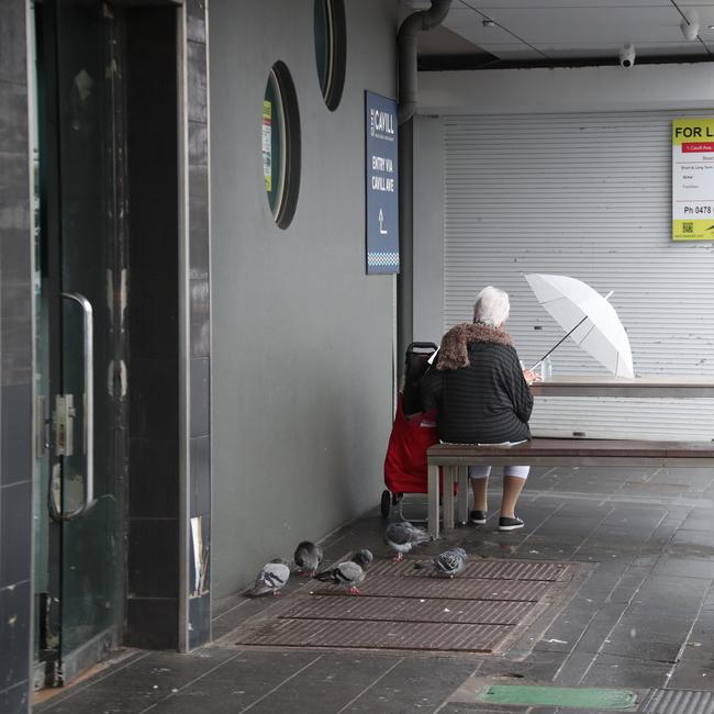 Day three of the Gold Coast lockdown. People and pidgeons keep dry at Surfers Paradise. Picture Glenn Hampson