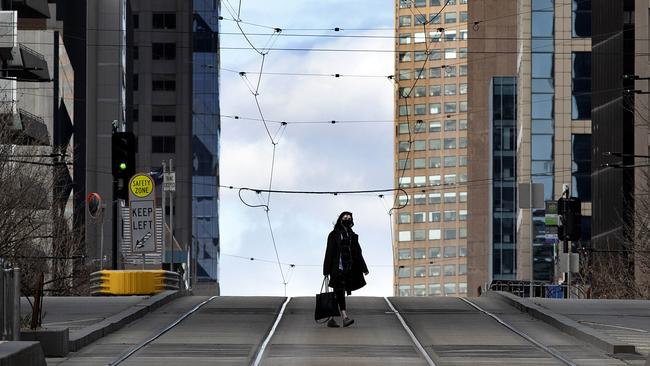 A woman crosses a deserted Collins St in Melbourne during stage four lockdowns. Picture: NCA NewsWire/David Geraghty