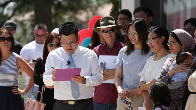 Place real estate agent Kevin Chiu with registered auction bidders at a home in Sunnybank Hills, where demand from Asian buyers is high. Picture: Tara Croser