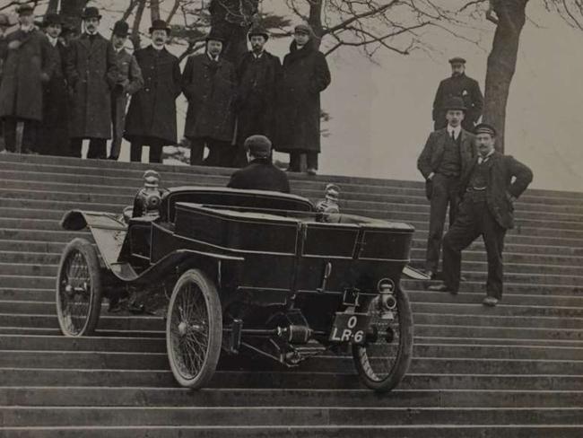 Lanchester test driver Archie Millership drives the 10hp Lanchester car up the steps in front of the Crystal Palace in 1904. Public domain