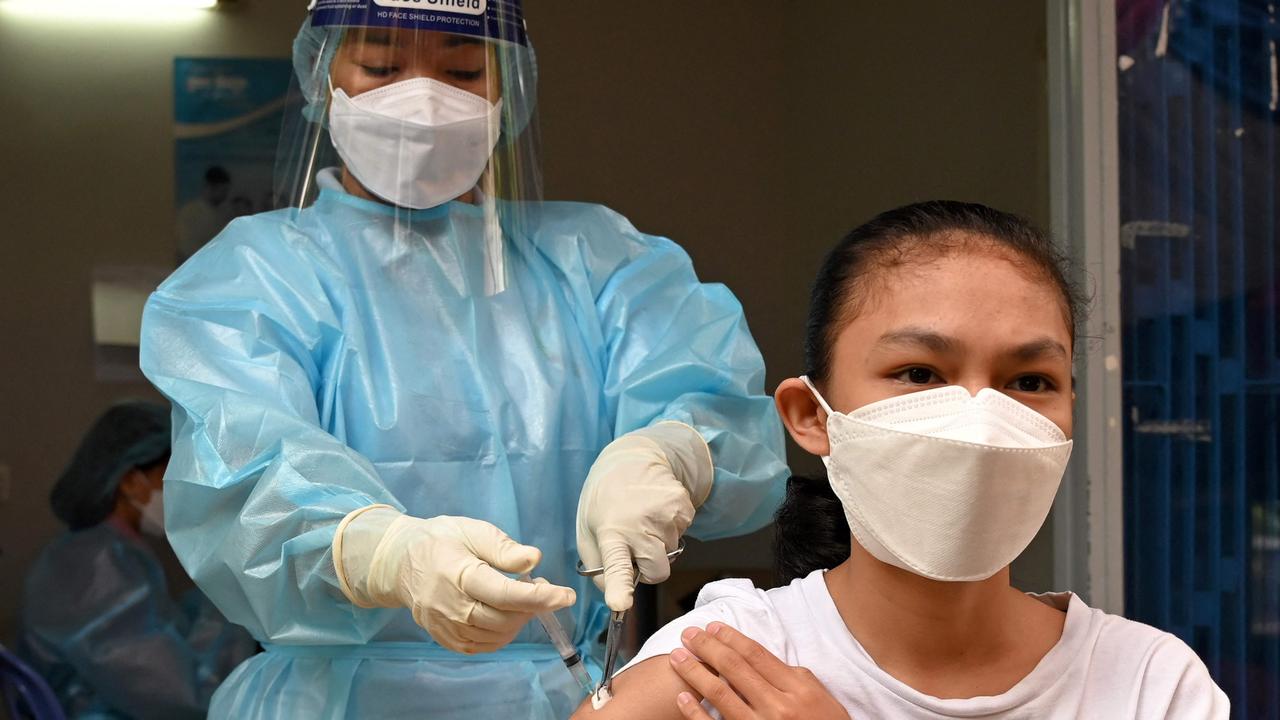 A young girl receives a Covid shot in Cambodia which this week will start immunising children from the age of six. Picture: Tang Chhin/AFP