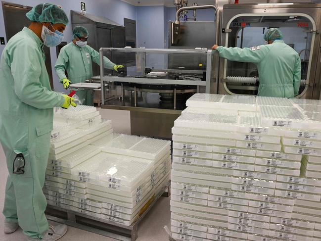 Laboratory technicians handle vaccine vials at a factory in Anagni that was raided by Italian police earlier this week. Picture: AFP