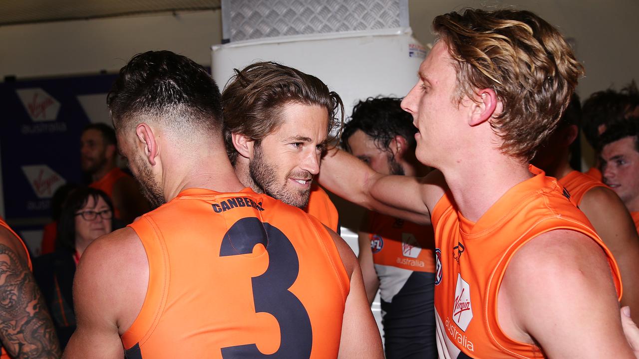 Callan Ward is hugged by Stephen Coniglio and Lachie Whitfield.