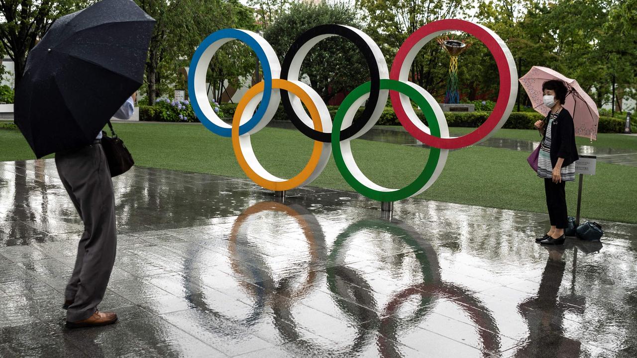 Olympic rings reflected in the rain near the National Stadium, main venue for the Tokyo 2020 Olympic and Paralympic Games, in Tokyo on June 23, 2021. Picture: AFP