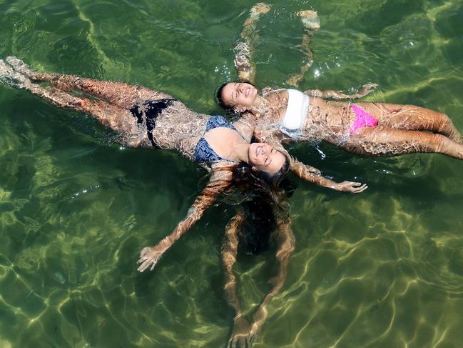 WEEKEND TELEGRAPHS SPECIAL. MUST TALK WITH PIC ED JEFF DARMANIN BEFORE PUBLISHING - Pictured at Manly Cove is Charlee Evers 16 and Daley Hodgson 16, with Zara Halliday 15 swimming underneath, keeping cool in the water as the temperature in Sydney hits 38 degrees today. Picture: Tim Hunter.