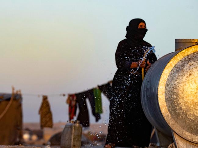 TOPSHOT - A Syrian woman fills a container with water at the Sahlah al-Banat camp in the countryside of Raqa, in northern Syria, on September 19, 2022. - The World Health Organization warned on September 14 of a "very high" risk of cholera spreading throughout Syria. The WHO said the latest cases were the first reported in the country since 2009, when 342 cases were confirmed in the eastern province of Deir Ezzor and the northern province of Raqa. (Photo by Delil SOULEIMAN / AFP)