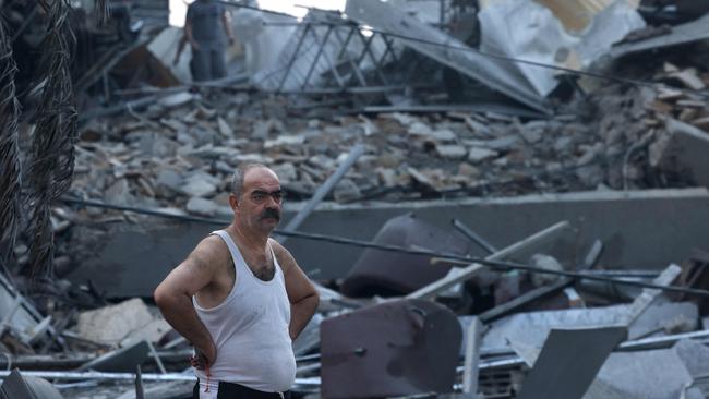 A Palestinian stands in front of the rubble of Gaza City's Al-Watan Tower, destroyed by an Israeli airstrike early on Sunday. Picture: AFP