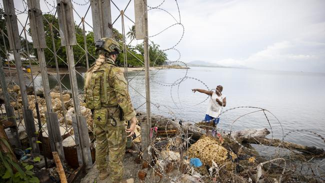 An Australian Army soldier on peacekeeping duty talks with a local fisherman at Guadalcanal Port on November 28, 2021 in Honiara, Guadalcanal Island, Solomon Islands.