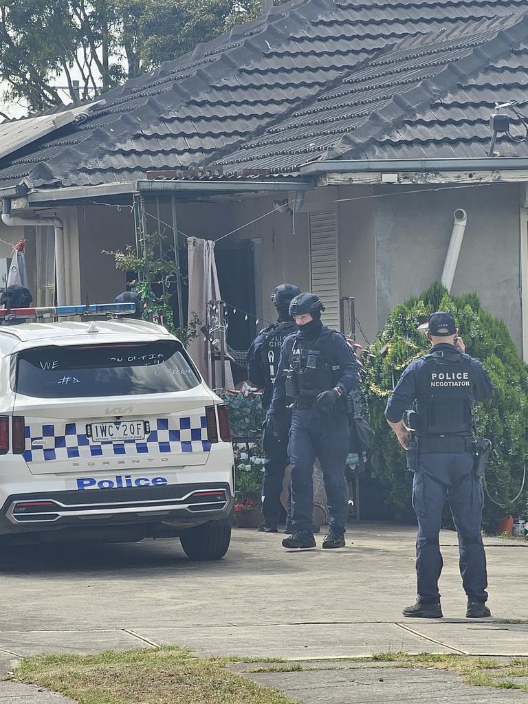 Heavily armed officers could be seen out the front of the home Picture: Jordan McCarthy