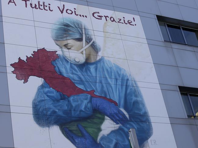 A giant image of a drawing by Venetian artist Franco Rivolli showing a doctor with wings on her back cradling Italy and writing in Italian reading, ‘To all of you... Thank you!’ Picture: AP