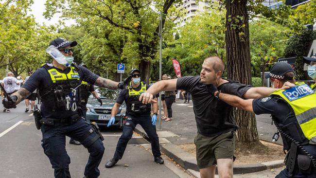 Anti-vaxxers protest against Covid-19 vaccinations at Fawkner Park in Melbourne. A protester clashes with police on St. Kilda Rd. Picture: Jake Nowakowski