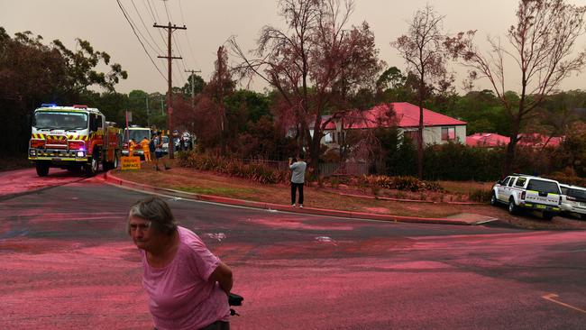 A resident walks in front of South Turramurra homes which were bombed by fire-retardant on November 12, 2019. Picture: Sam Mooy/Getty